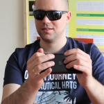 Egy látássérült ember az okostelefon kijelőjén megjelenő braille billentyűzetet használja
